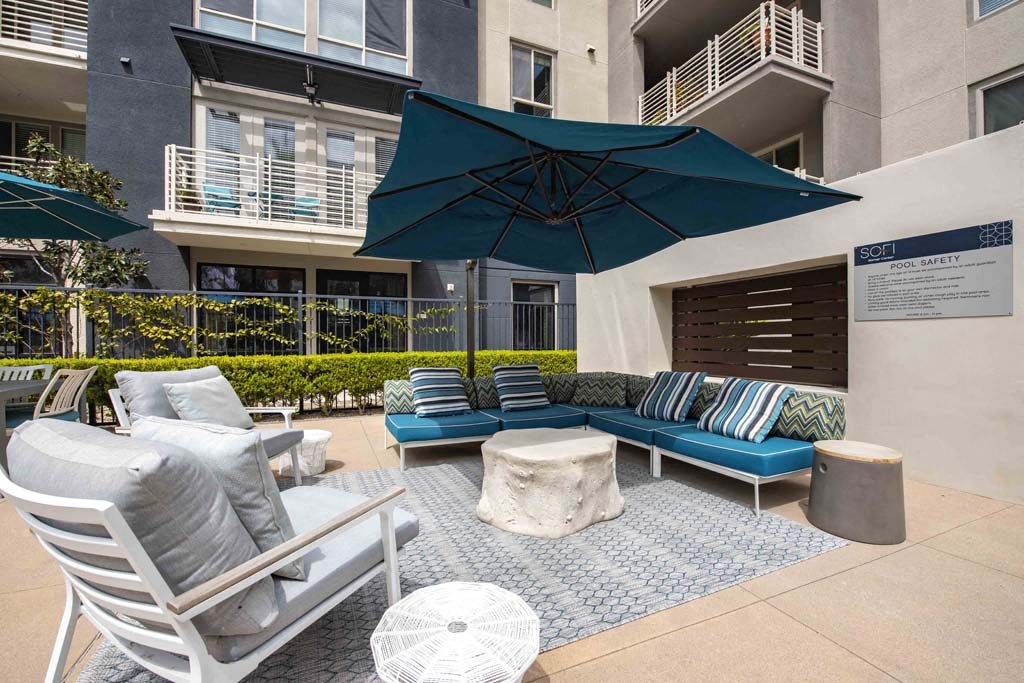a patio with furniture and an umbrella in an apartment building