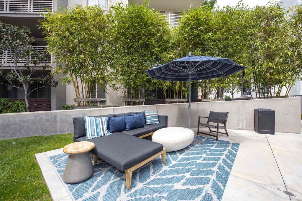 a patio with a couch and an umbrella
