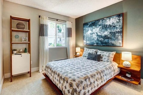 a bedroom with a bed and a painting on the wall