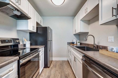 a kitchen with stainless steel appliances and white cabinets