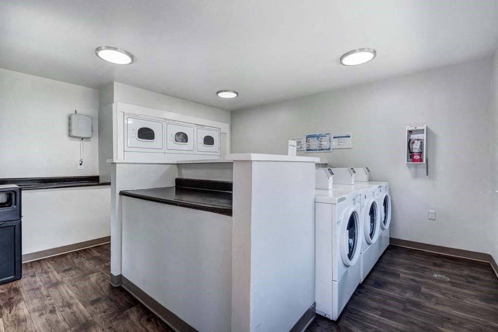 a laundry room with washes and dryers and a counter with two washes