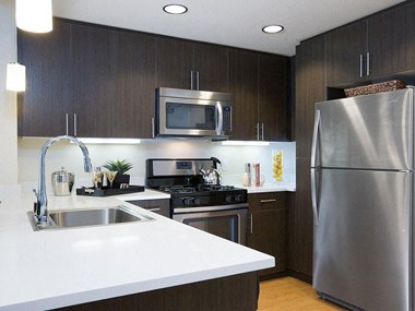 Modern kitchen with stainless steel appliances and white counter tops