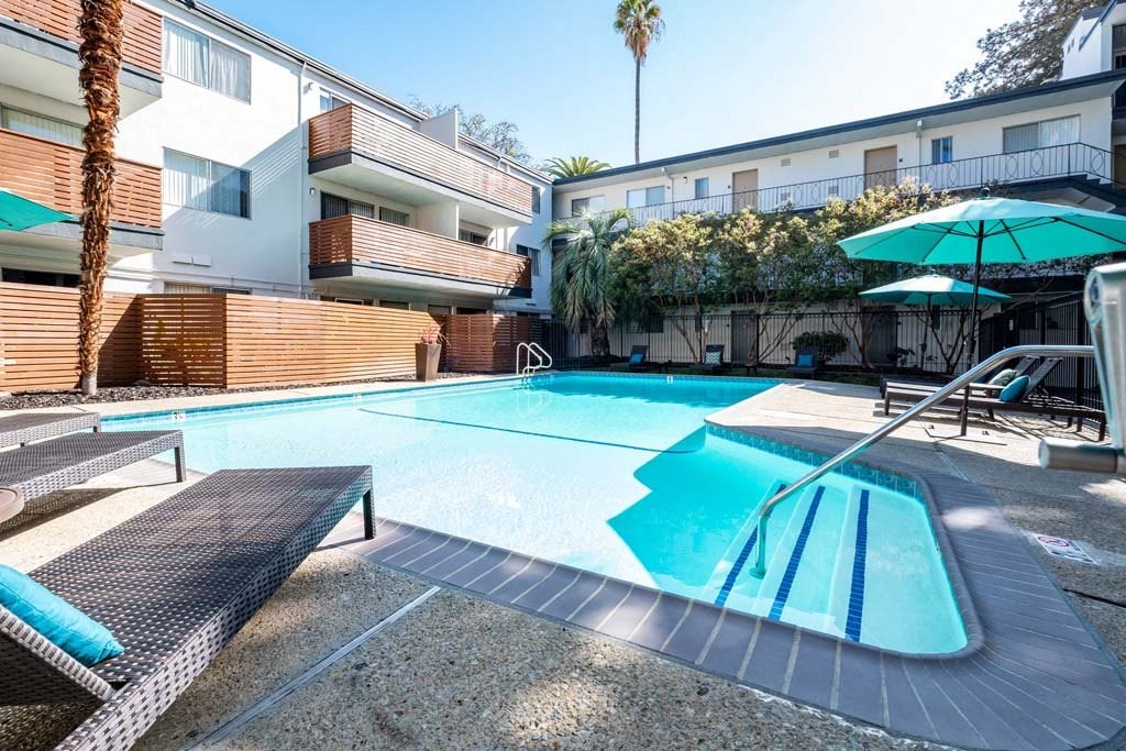 a swimming pool with an apartment building in the background