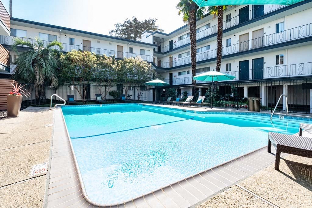 a large swimming pool in front of a hotel