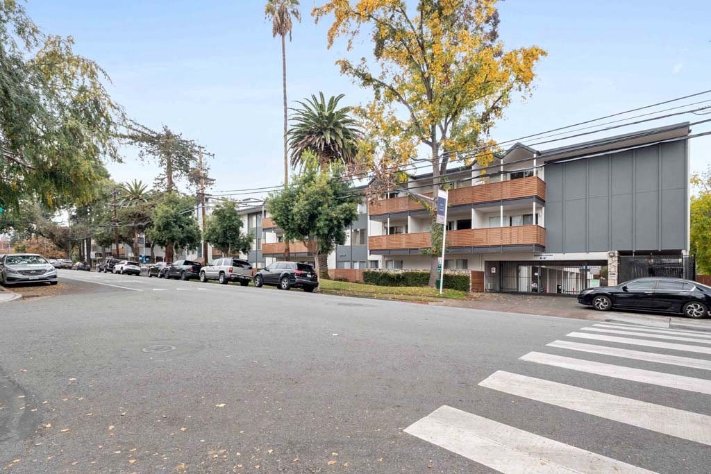 an empty street in front of a building with cars parked on the street