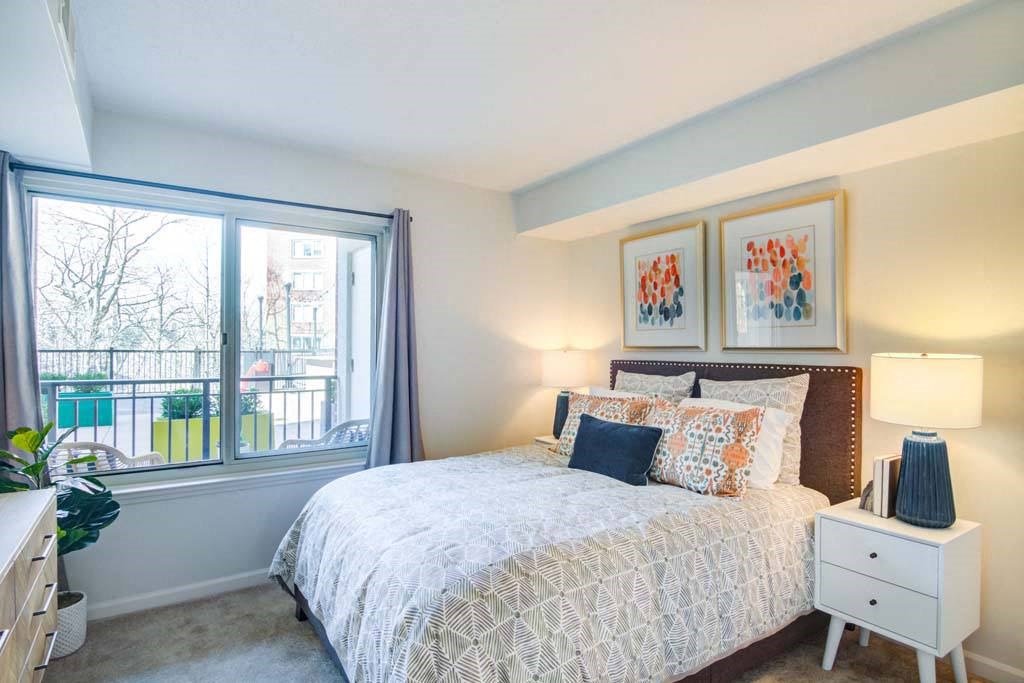 a bedroom with a bed and a large window