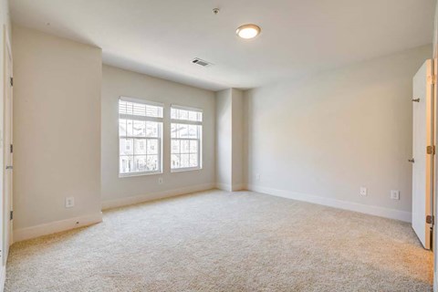 an empty living room with a door and a window