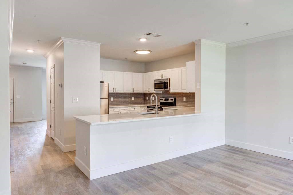 an empty kitchen with white cabinets and a counter top