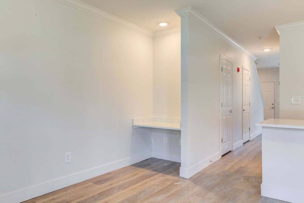 a living room with white walls and wood floors