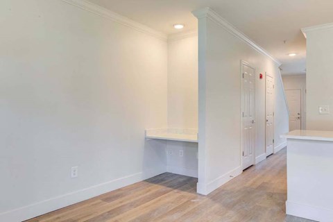 a living room with white walls and wood floors