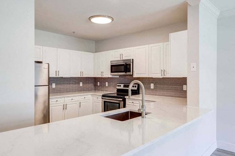 a large kitchen with white cabinets and a sink