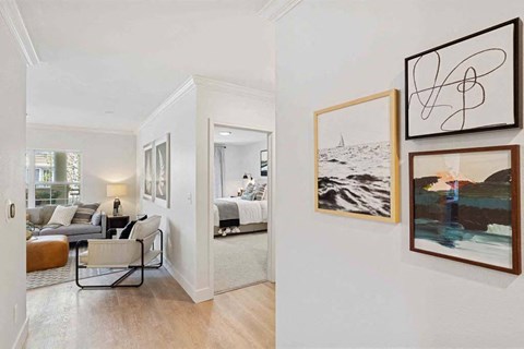 a living room with pictures on the wall    and a bedroom