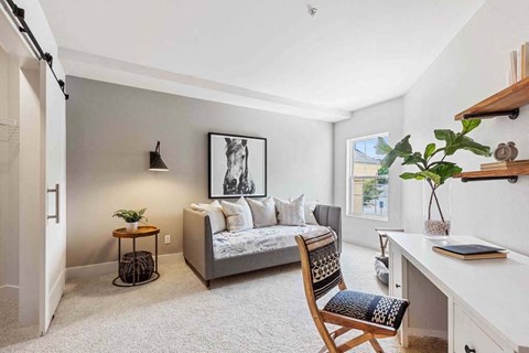 a living room with a couch and a desk