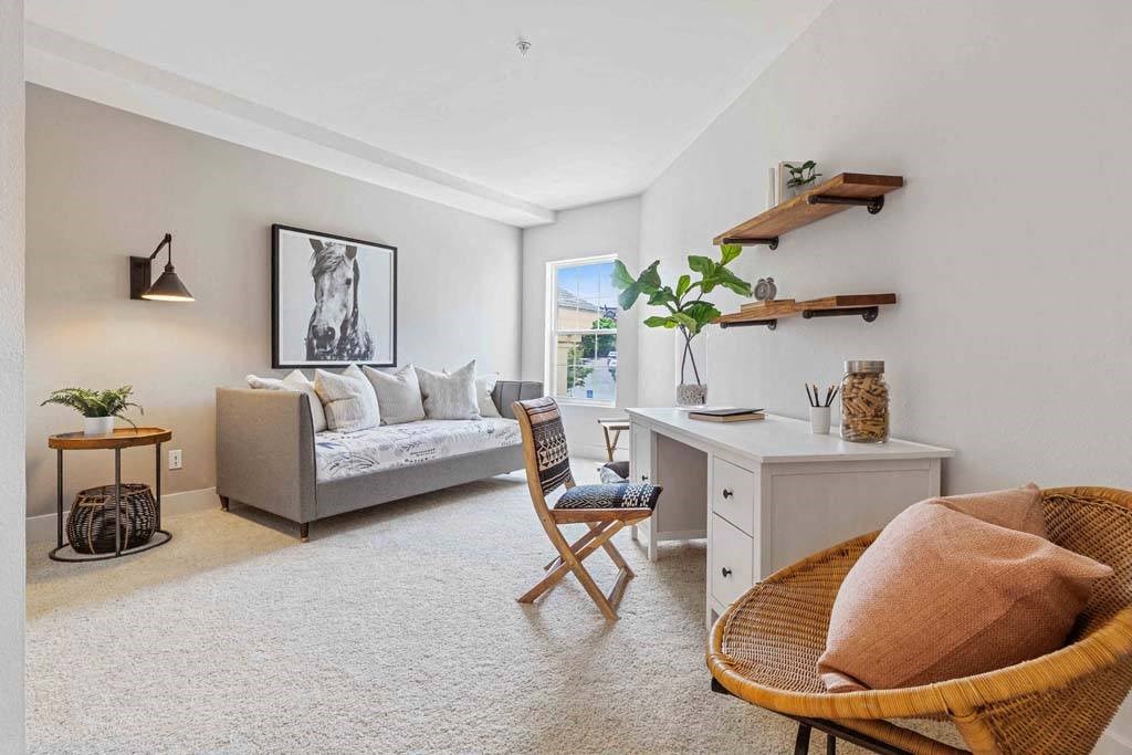 a living room with a couch and a desk and a chair