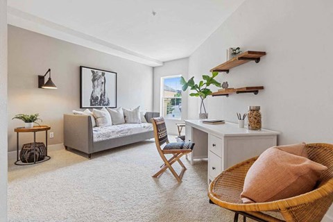 a living room with a couch and a desk and a chair