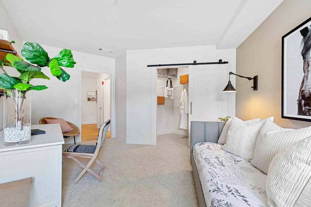 a living room with a couch and a hallway to a bedroom