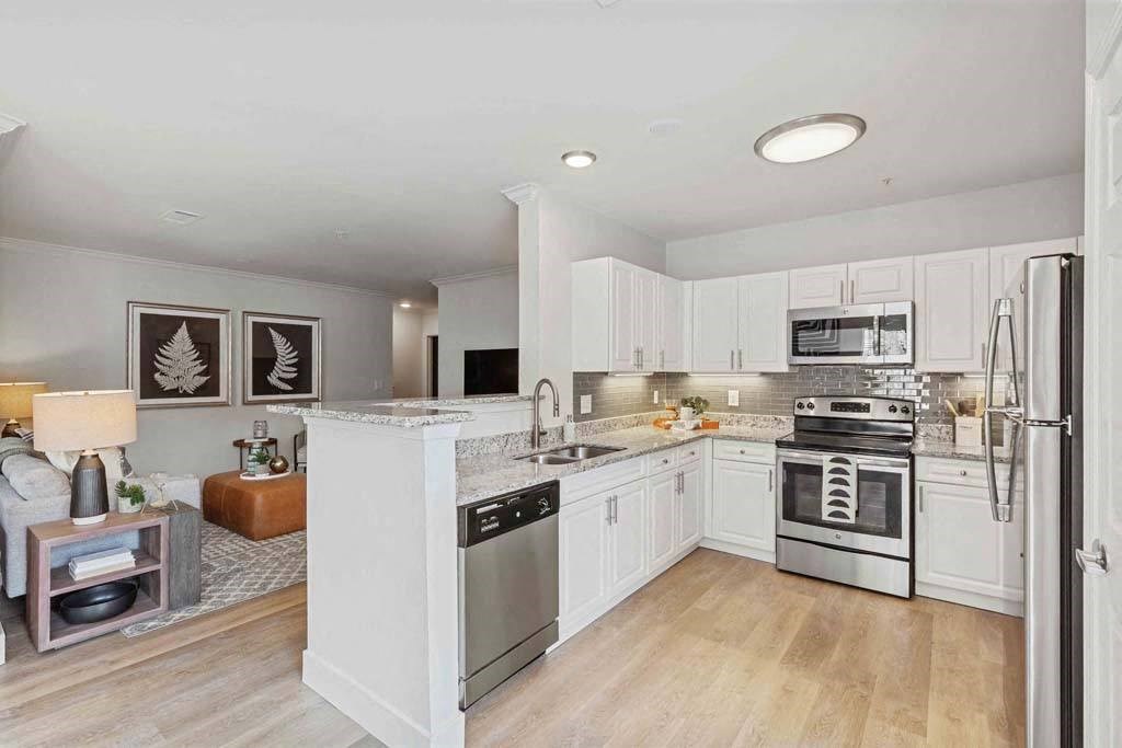 a kitchen with white cabinets and stainless steel appliances
