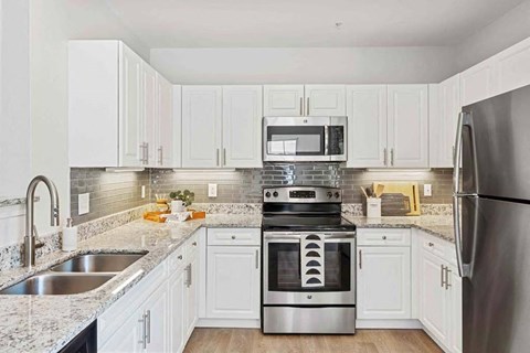 a kitchen with white cabinets and stainless steel appliances