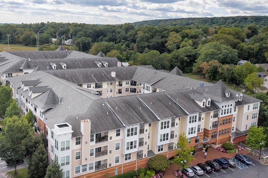 an aerial view of an apartment building with a parking lot