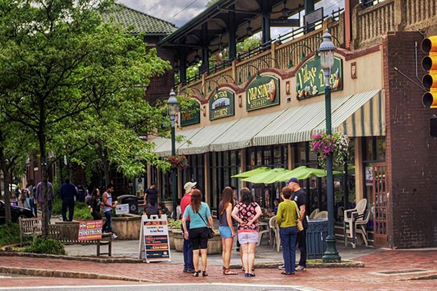 a group of people walking down a street in front of a restaurant