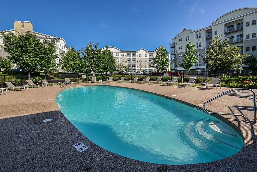 a large swimming pool in front of an apartment building