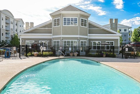 A large building with a pool in front of it.