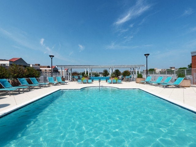 a large swimming pool with blue lounge chairs