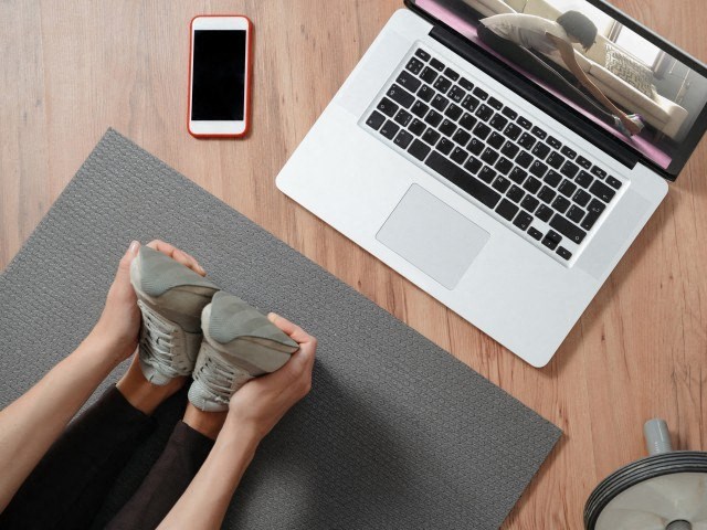 a woman sitting at a desk with her feet up on a laptop