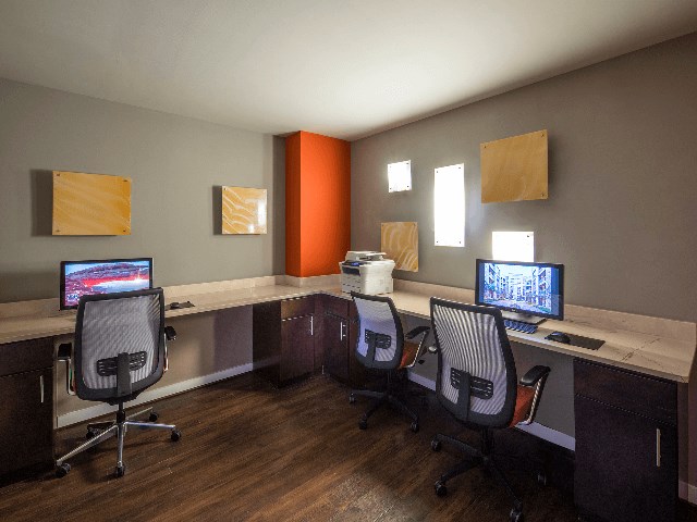 a room with three computer desks and three monitors