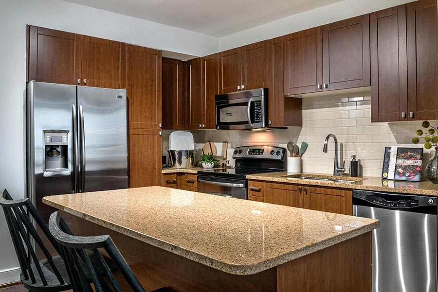 a kitchen with a granite counter top and a stainless steel refrigerator