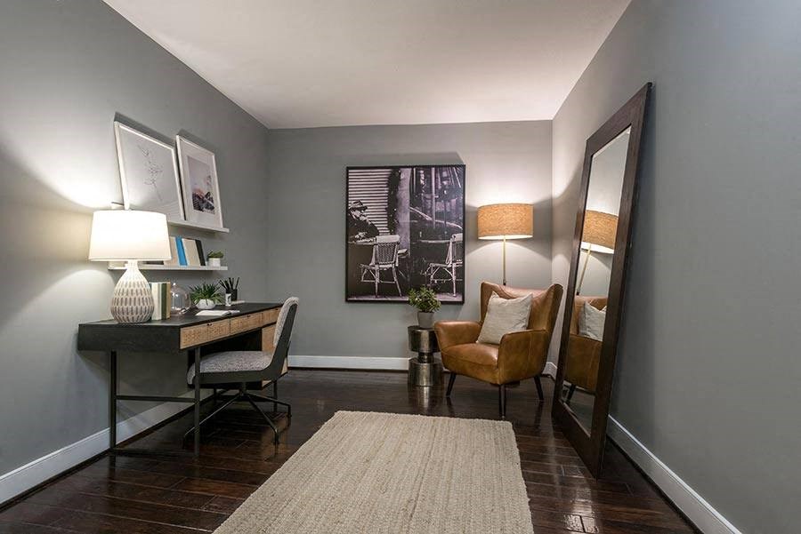 a living room with a desk and a mirror