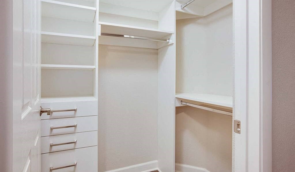 an empty closet with shelves and drawers