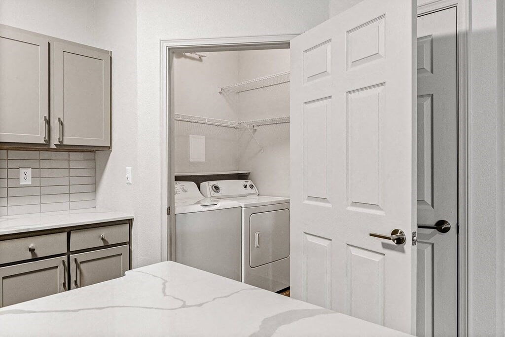 a white kitchen with a white door and white appliances