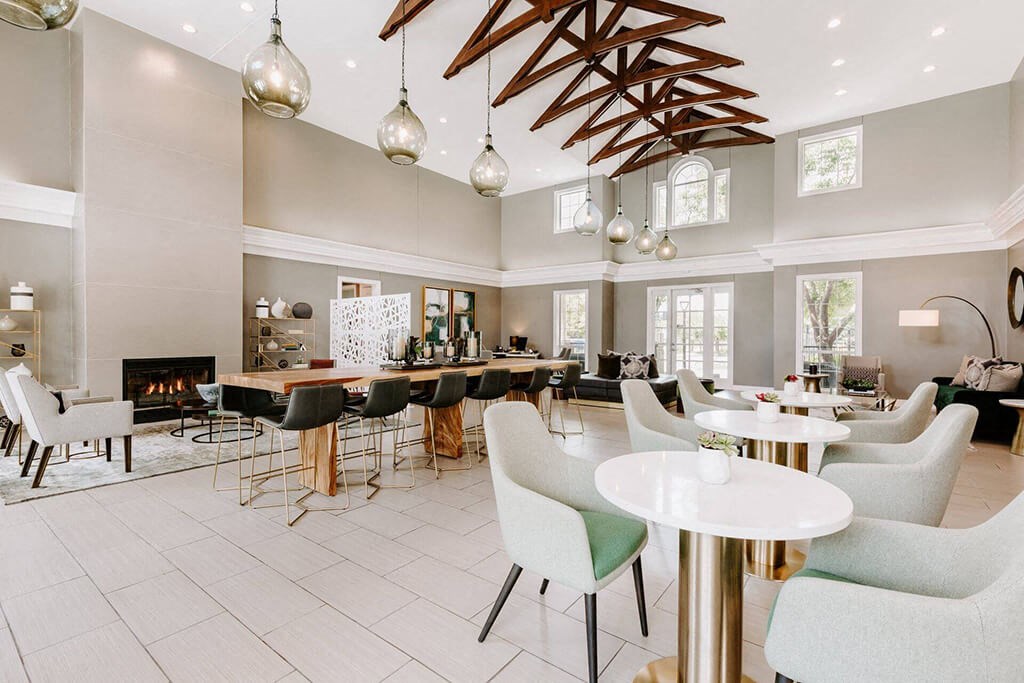a large living room with tables and chairs and a fireplace