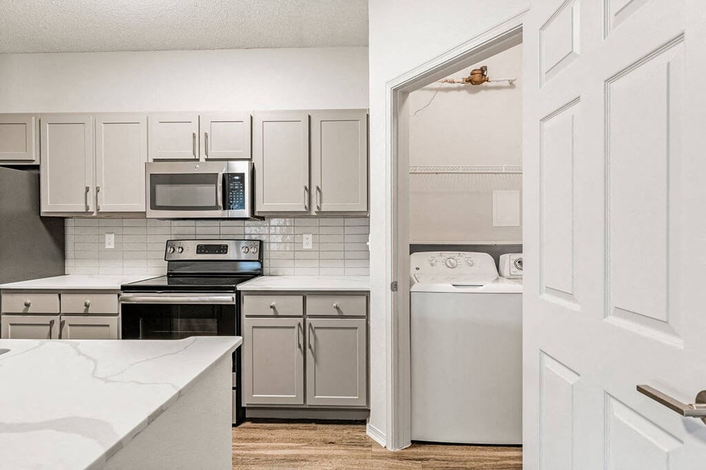 a kitchen with white cabinets and white appliances