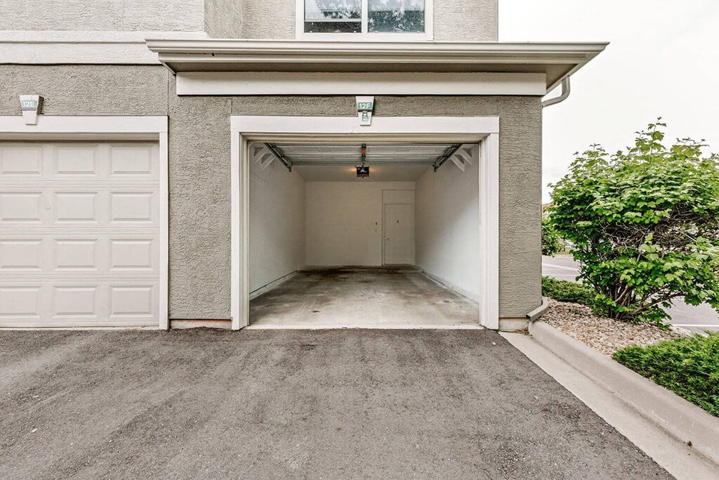 a white garage door on the side of a driveway