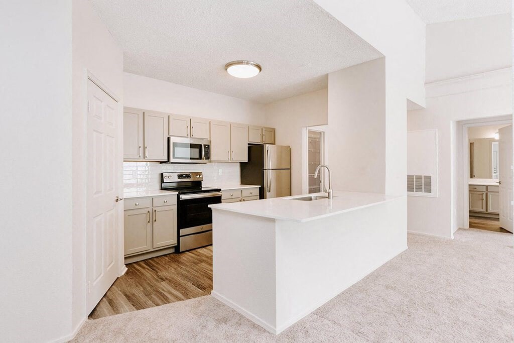 a renovated kitchen with white cabinets and a white counter top