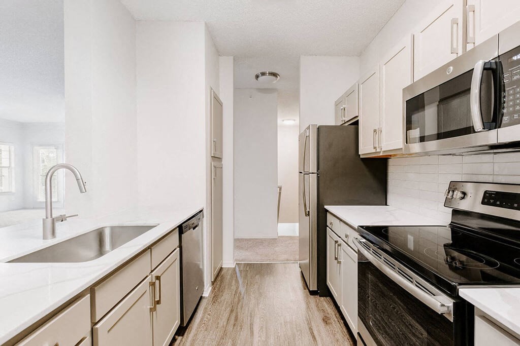 a kitchen with stainless steel appliances and white cabinets