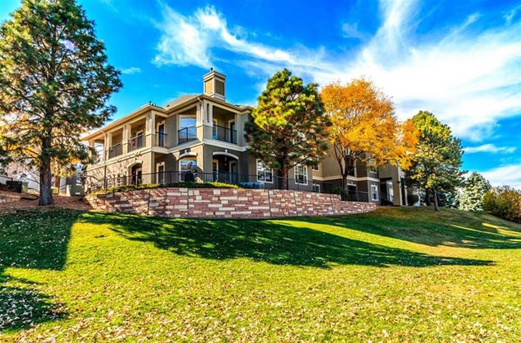 a large house on a hill with grass and trees