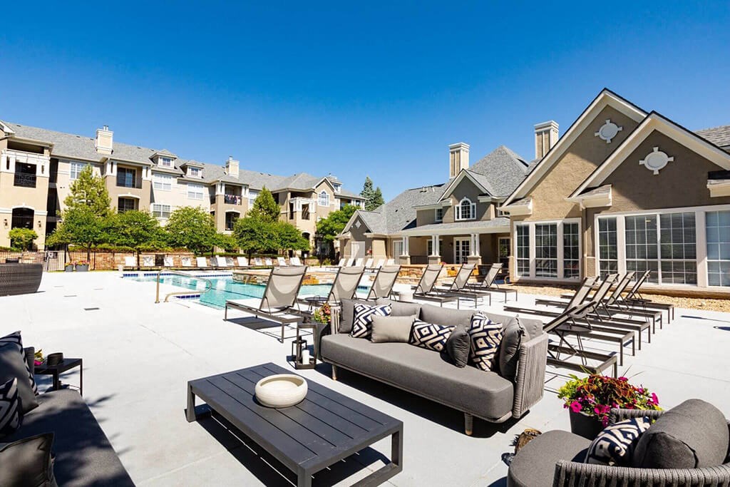 a large patio with furniture and a swimming pool