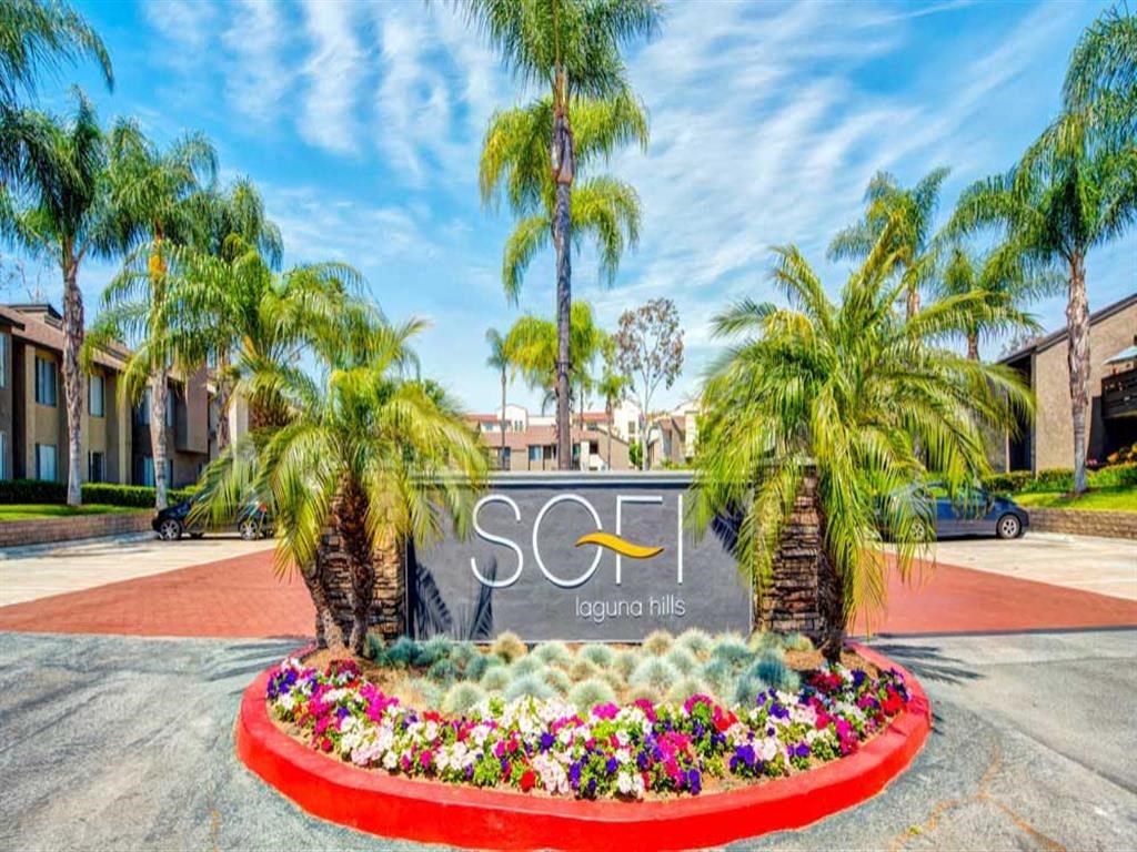 the sign at the entrance apartments with palm trees