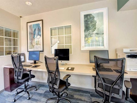 an office with two desks and two chairs and a computer
