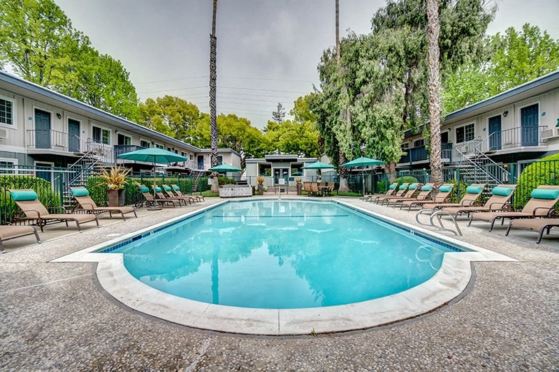 our apartments have a resort style pool with chairs and umbrellas