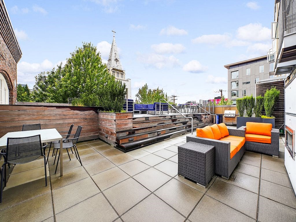 a roof terrace with a couch and tables