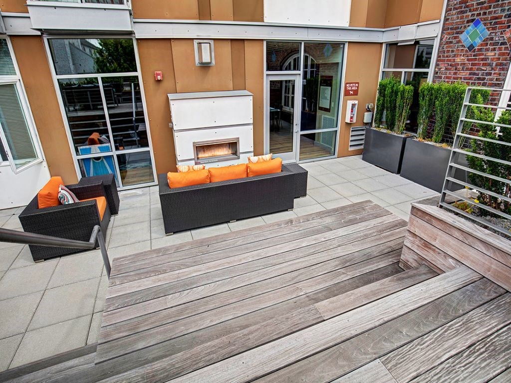 a patio with a fireplace and a wooden deck