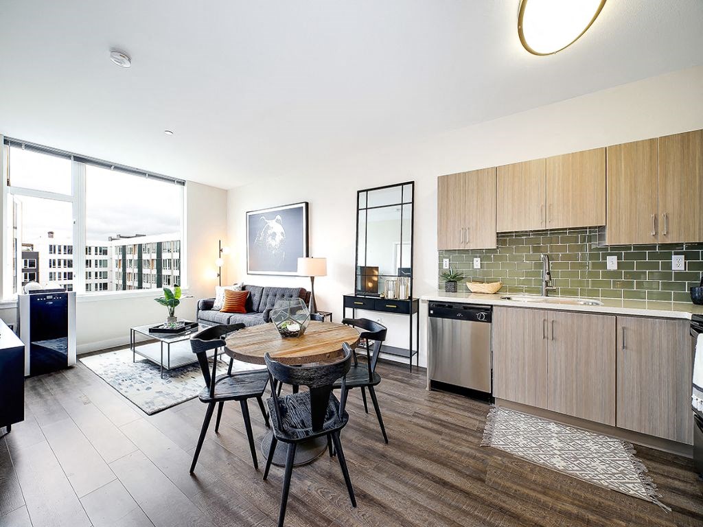 a living room with a table and a kitchen