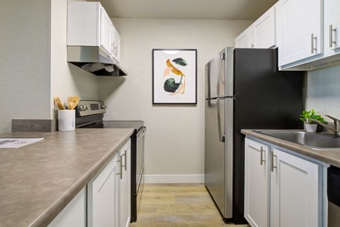 a kitchen with stainless steel appliances and white cabinets