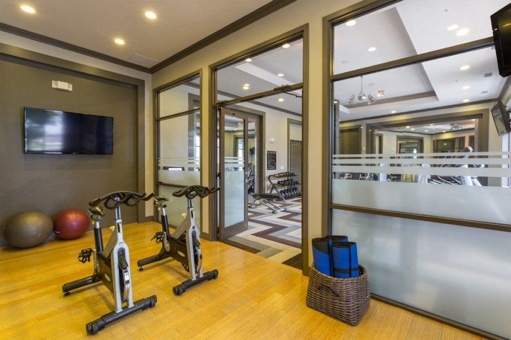 a home gym with weights and a tv on the wall