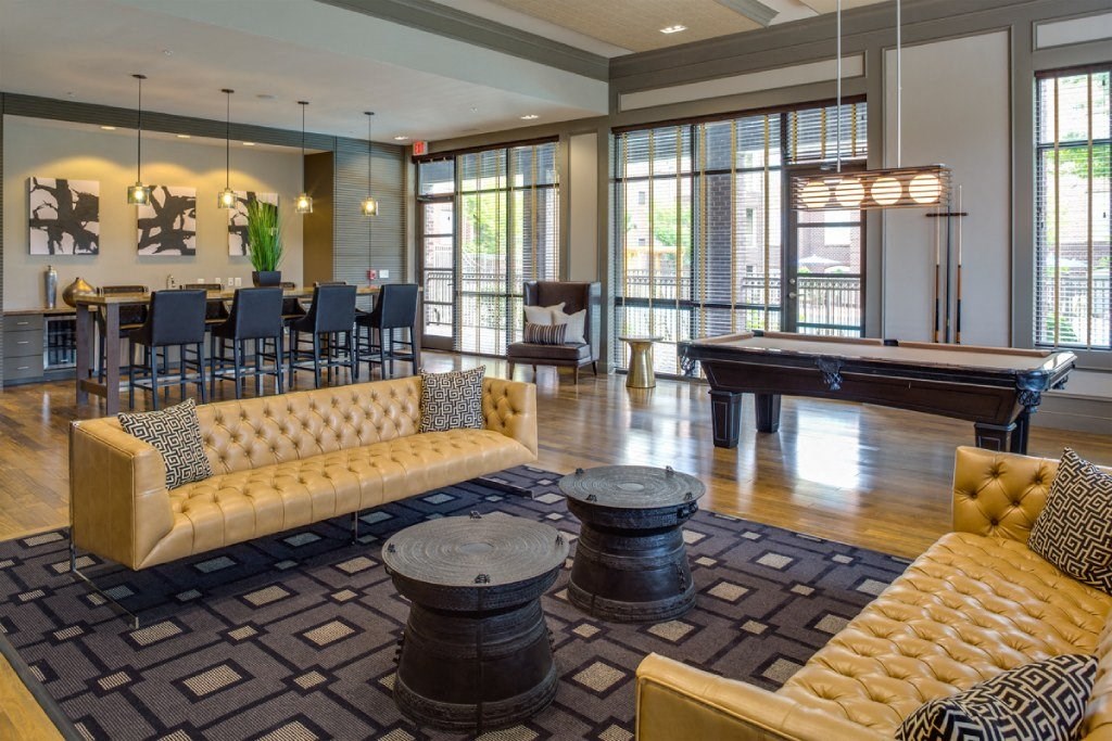 a clubhouse with a pool table and couches