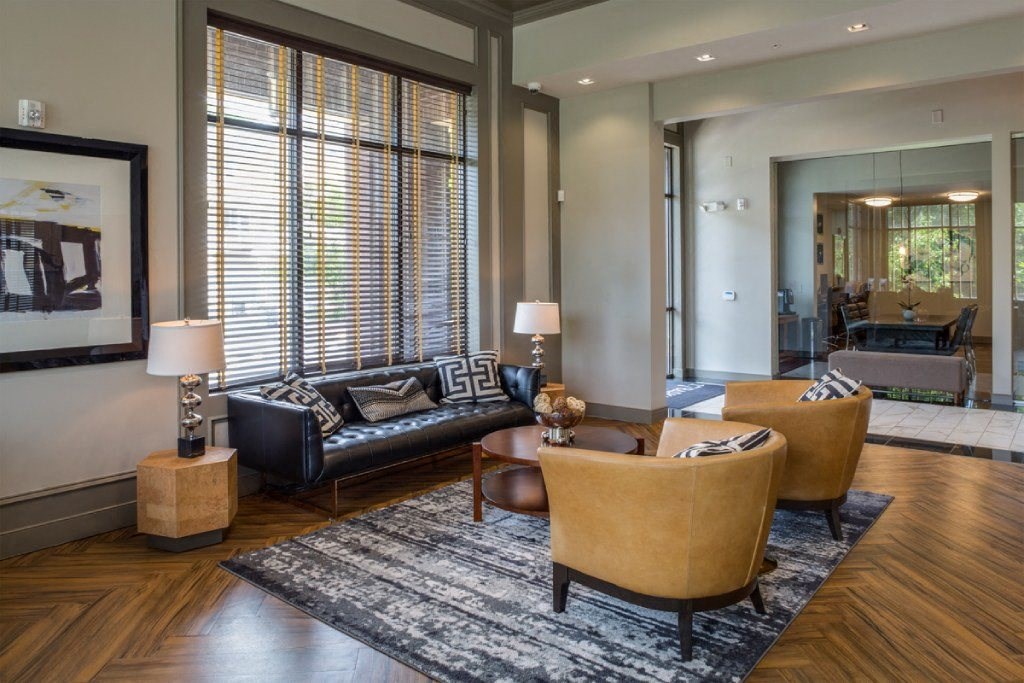 a living room with a couch and chairs and a rug